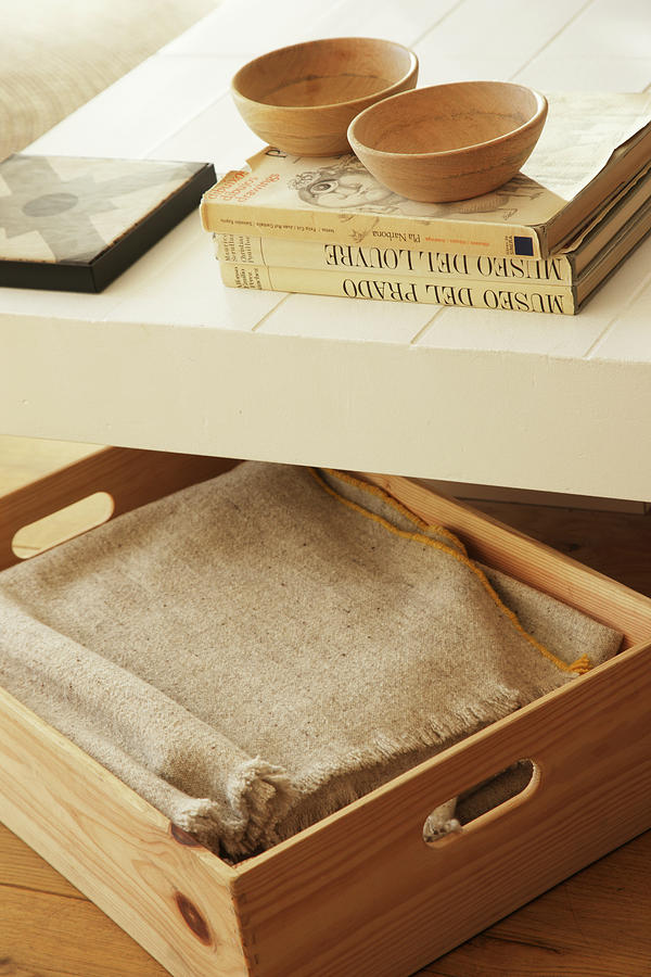 Blanket In Wooden Box Under Books And Bowls On Coffee Table Photograph by Jos-luis Hausmann