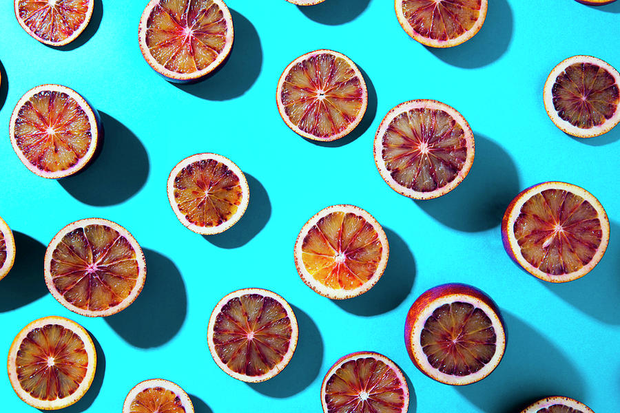 Blood Orange Halves On A Turquoise Background Photograph by Andr Ainsworth