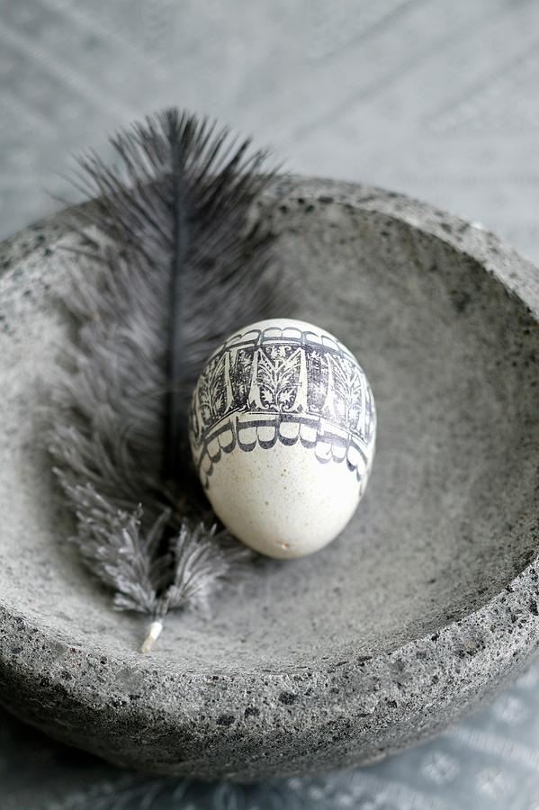 Blown Egg Decorated With Black, Printed Pattern And Feather In Stone Dish Photograph by Bjarni B. Jacobsen
