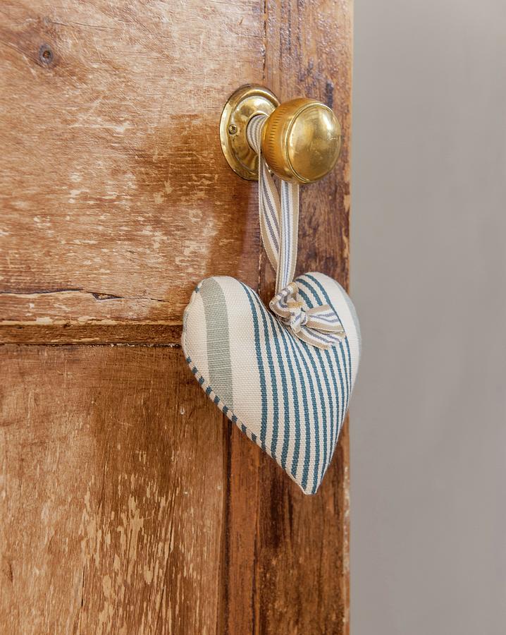 Blue And White Striped Fabric Love-heart Hung From Knob Of Wooden Door Photograph by Stuart Cox