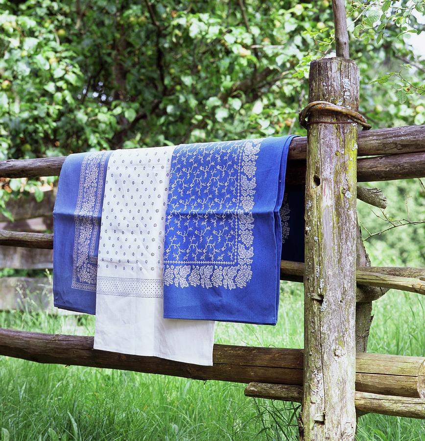 Blue And White Table Linen Hanging Over Wooden Fence Photograph by Jeanette Schaun