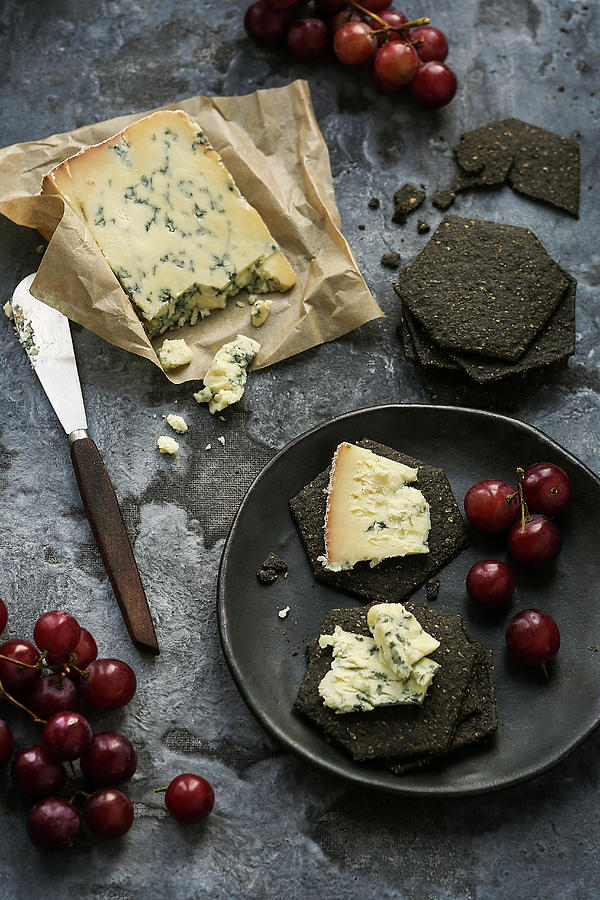Blue Cheese With Charcoal Biscuits And Red Grapes Photograph by Stacy Grant