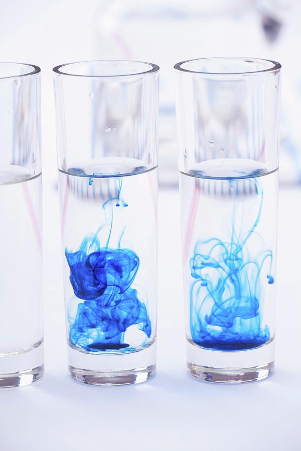 Blue Colouring Dispersing In Glasses Of Water Photograph by Studio Lipov