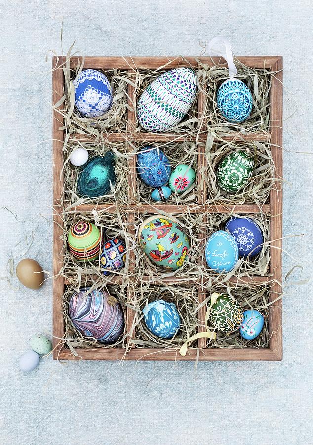 Blue, Hand-painted Easter Eggs In A Wooden Seedling Tray Lined With Straw Photograph by Jalag / Christine Bauer