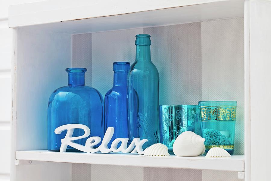 Blue Ornamental Bottles And Glasses On White Shelf Photograph by Uwe Merkel