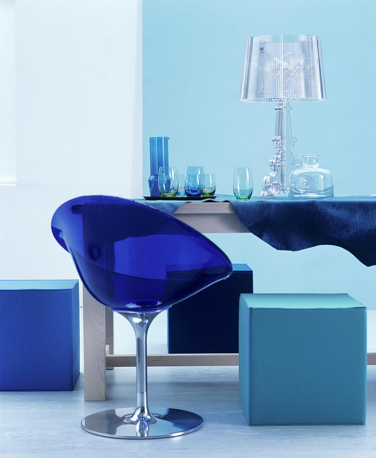 Blue Plastic Chair And Cubic Pouffe Around Glasses And Lamp On Table Photograph by Matteo Manduzio