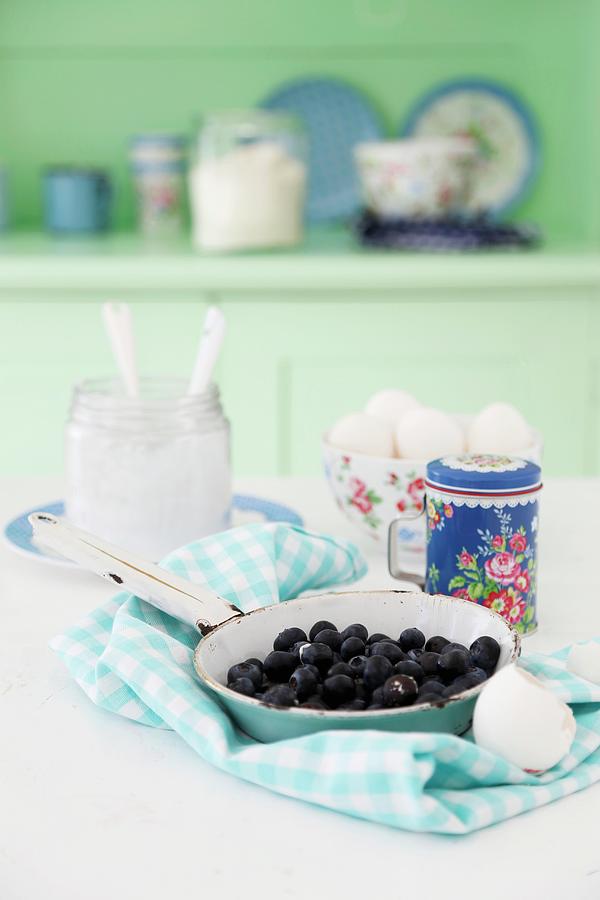 Blueberries In An Enamel Pan On A Blue And White Napkin With Quark And Eggs In The Background Photograph by Syl Loves