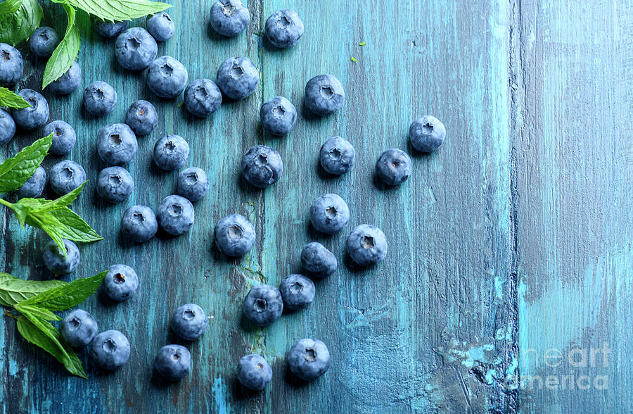 Blueberries ion blue wooden table Photograph by Jelena Jovanovic