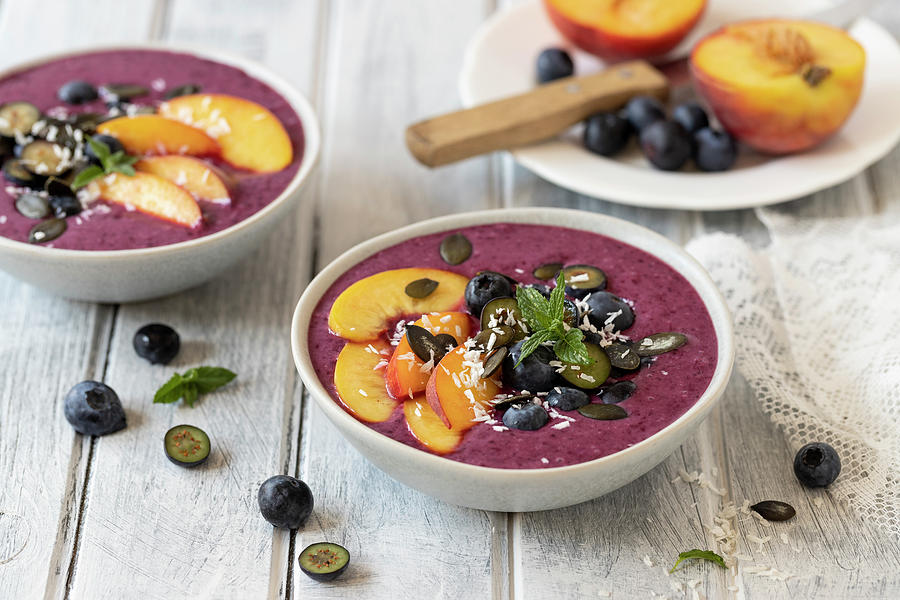 Blueberry Smoothie Bowl With Peach Slices, Blueberries And Pumpkin Seeds Photograph by Zuzanna Ploch