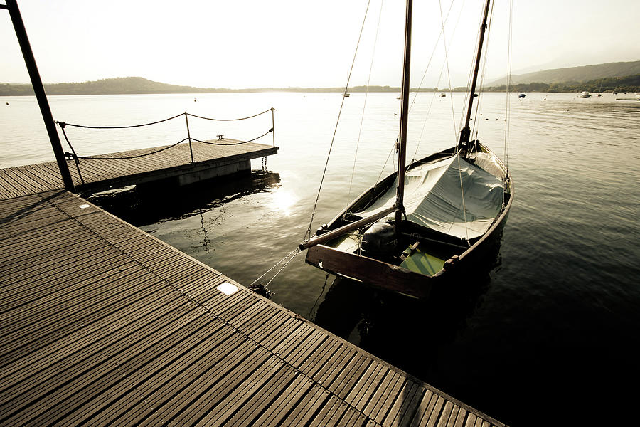 Boat Moored To The Wooden Pier On Lake Photograph by Paolomartinezphotography