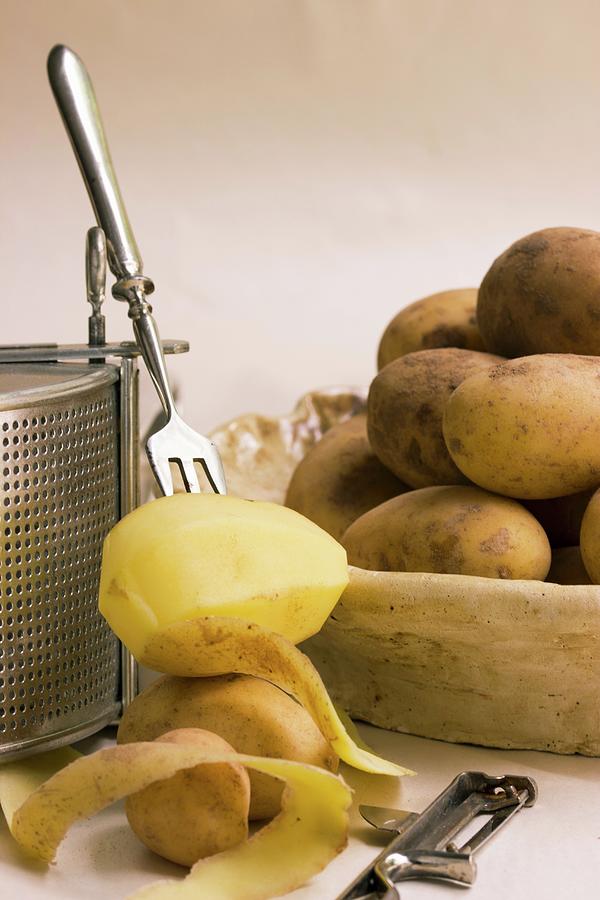 Boiled Potatoes And A Half Peeled Potato On A Fork Photograph by Charlotte Von Elm
