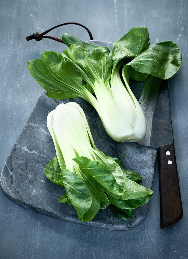 Bok Choy On A Grey Marble Board With A Knife Photograph by Stefan Schulte-ladbeck