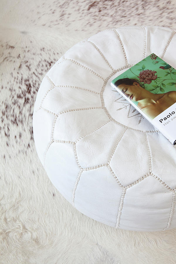 Book On White Leather Pouffe On White Cowhide Rug Photograph by Gonkel/stegeman