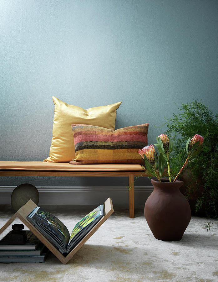 Book Table And Floor Vase In Front Of Bench With Cushions Photograph by Anderson Karl