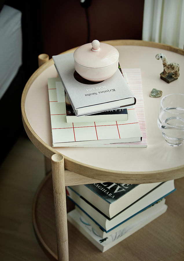 Books And Porcelain Pot With Lid On Round Bedside Table Photograph by Bjarni B. Jacobsen