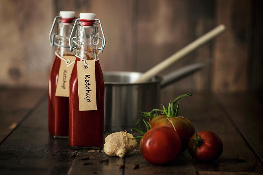 Bottle Of Homemade Ketchup With Ingredients And Kitchen Utensils On A Wooden Table Photograph by Jan Wischnewski