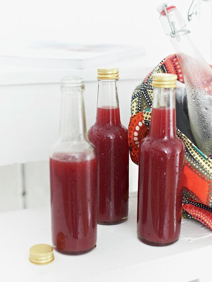 Bottles Of Home-made Grape, Apple And Mango Lemonade Photograph by Hannah Kompanik