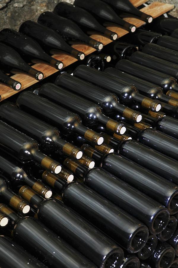 Bottles Of Wine In A Wine Cellar Photograph by Jean-marc Blache