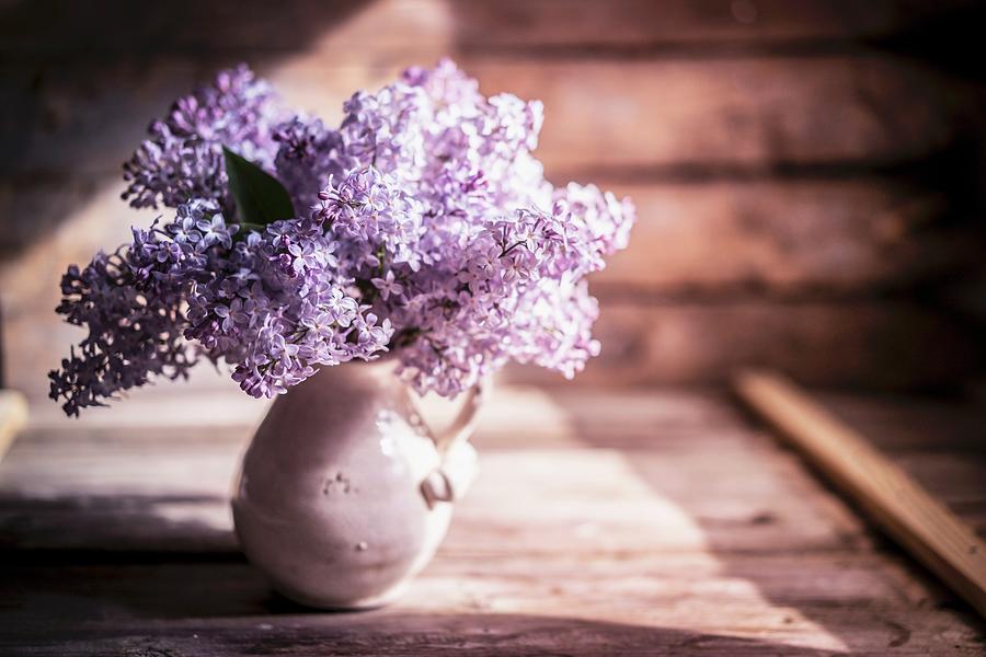 Bouquet Of Lilac Against Wooden Background Photograph by Alena Haurylik