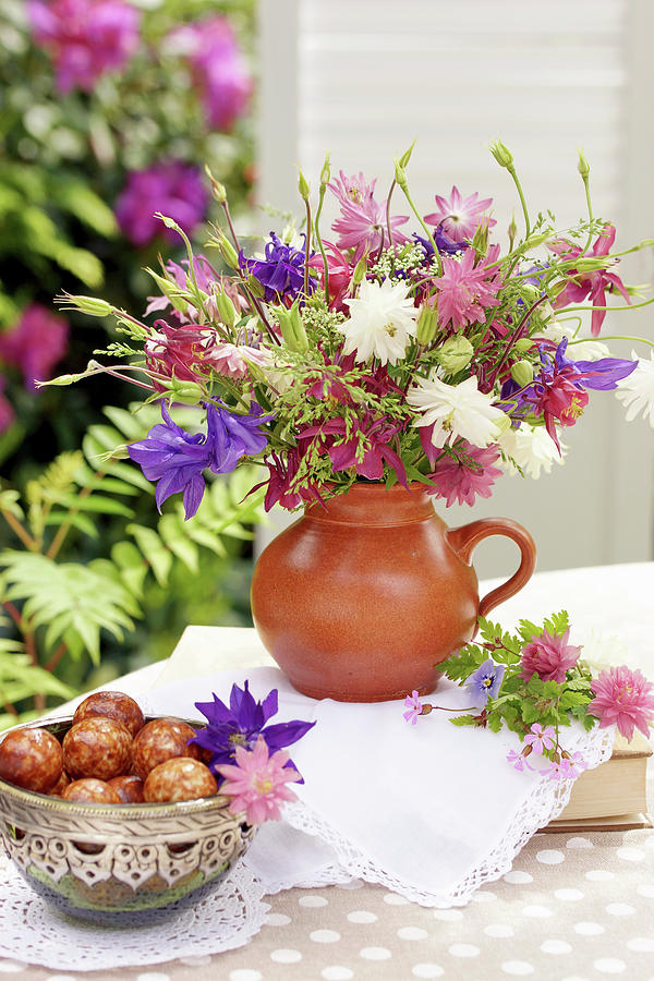 Bouquet Of Mixed Aquilegias And Bowl Of Pastries On Terrace Table Photograph by Angelica Linnhoff