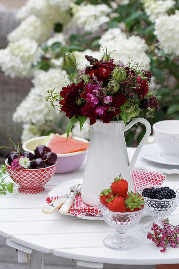 Bouquet Of Red Summer Flowers And Love-in-a-mist Seed Pods And Bowls With Strawberries, Cherries, And Blackberries Photograph by Angelica Linnhoff