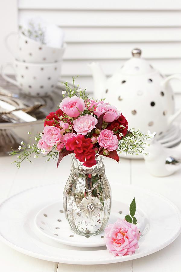 Bouquet Of Roses With Cockscomb And Gypsophila In Silvered Glass Vase In Front Of Polka-dot Tea Set Photograph by Angelica Linnhoff