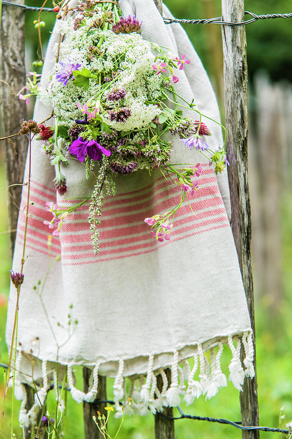 Bouquet Of Wildflowers And Cotton Towel Hung On Garden Fence Photograph by Bildhbsch