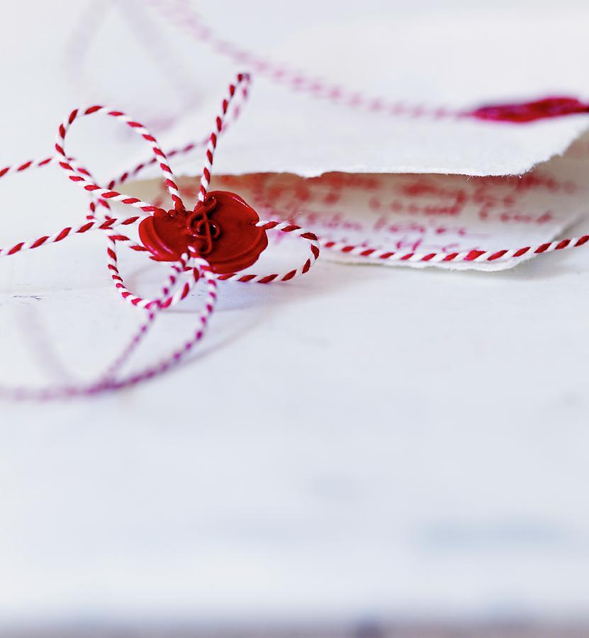 Bow Of Red And White Bakers Twine Sealed With Sealing Wax And Stamp Of Treble Clef Photograph by Andreas Hoernisch