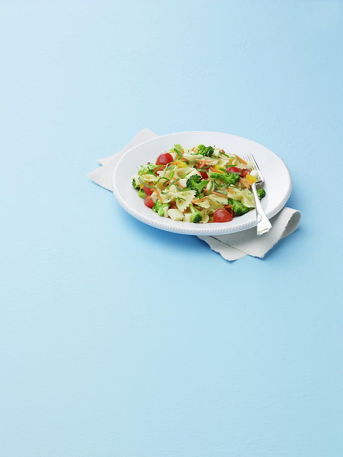 Bow Tie Pasta Salad With Broccoli And Tomatoes On A White Plate Photograph by Comet, Rene