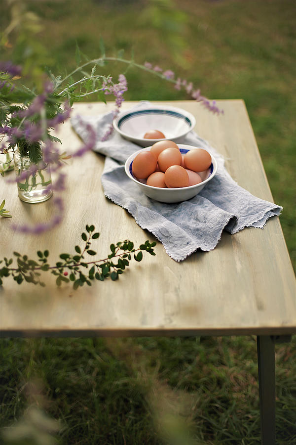 Bowl Of Eggs On Cloth On Table In Garden Photograph by Alicja Koll