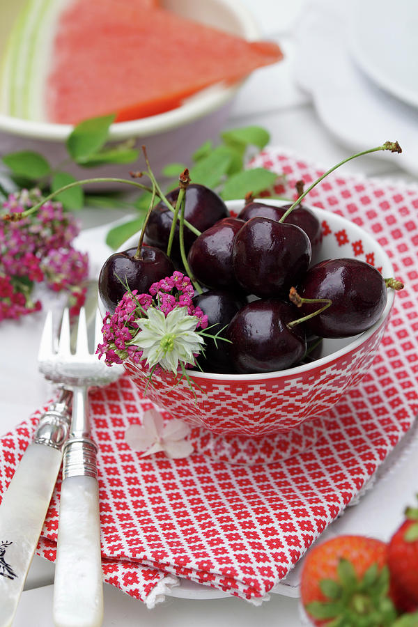 Bowl Of schwarze Knorpelkirsche Cherries With Love-in-a-mist And Pink Yarrow Flowers Photograph by Angelica Linnhoff