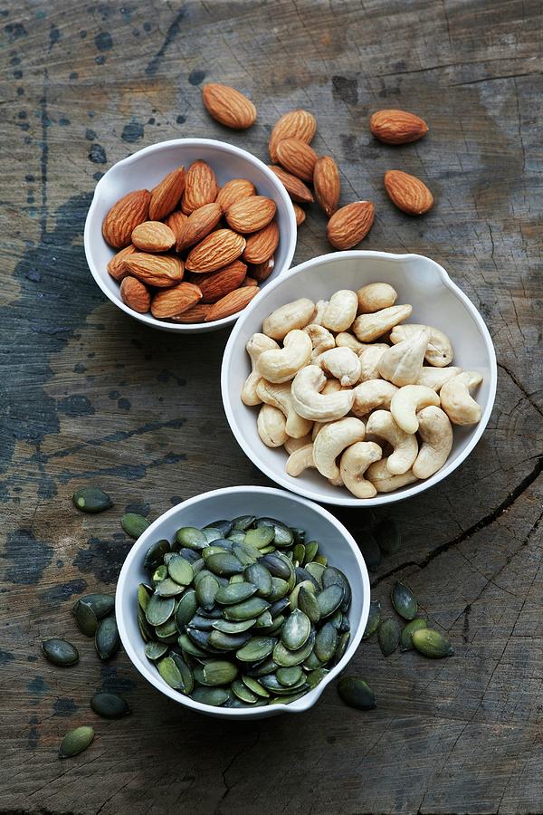 Bowls Of Almonds, Cashew Nuts And Pumpkin Seeds Photograph by Victoria Firmston