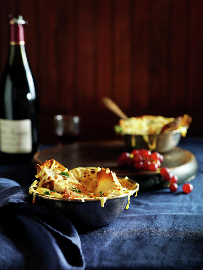 Bowls Of French Onion Soup With A Bottle Of Red Wine Against Dark Wood Photograph by Justin B. Paris