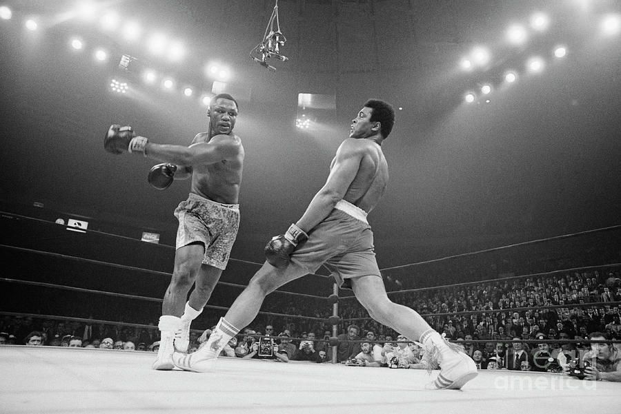 Joe Frazier Photograph - Boxer Ali Dodging A Punch From Frazier by Bettmann