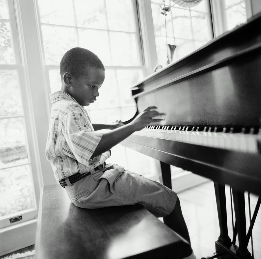 Boy 6-8 Playing Piano In Home B&w Photograph by Tony Anderson