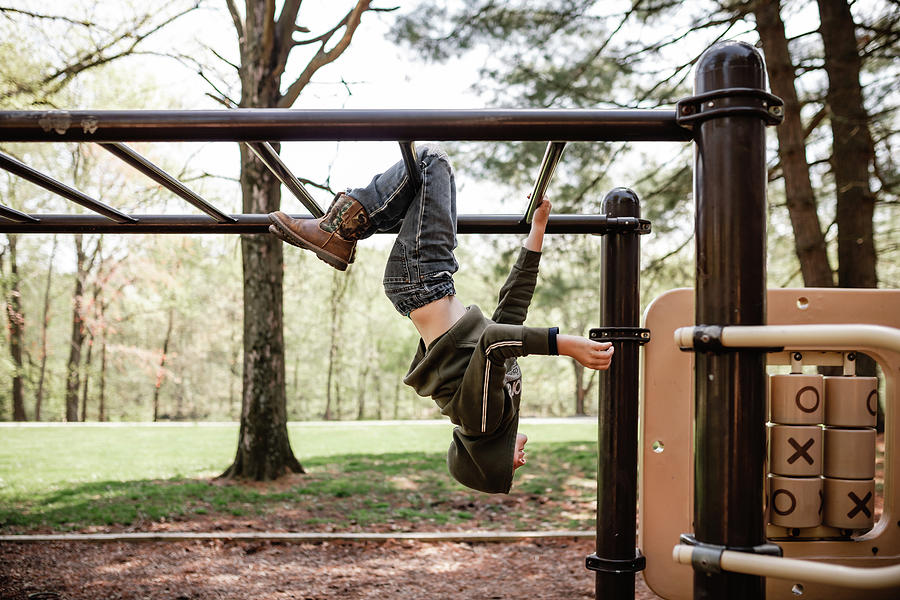 Spring Photograph - Boy At Playground Hanging On Monkey Bars by Cavan Images / Krista Taylor