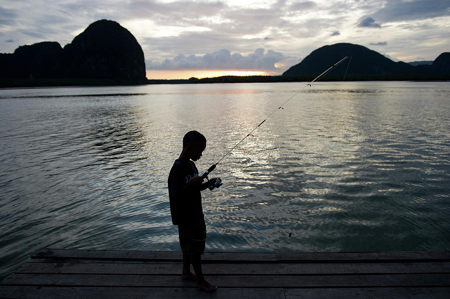 Boy Fishing On Pier Photograph by Kampee Patisena