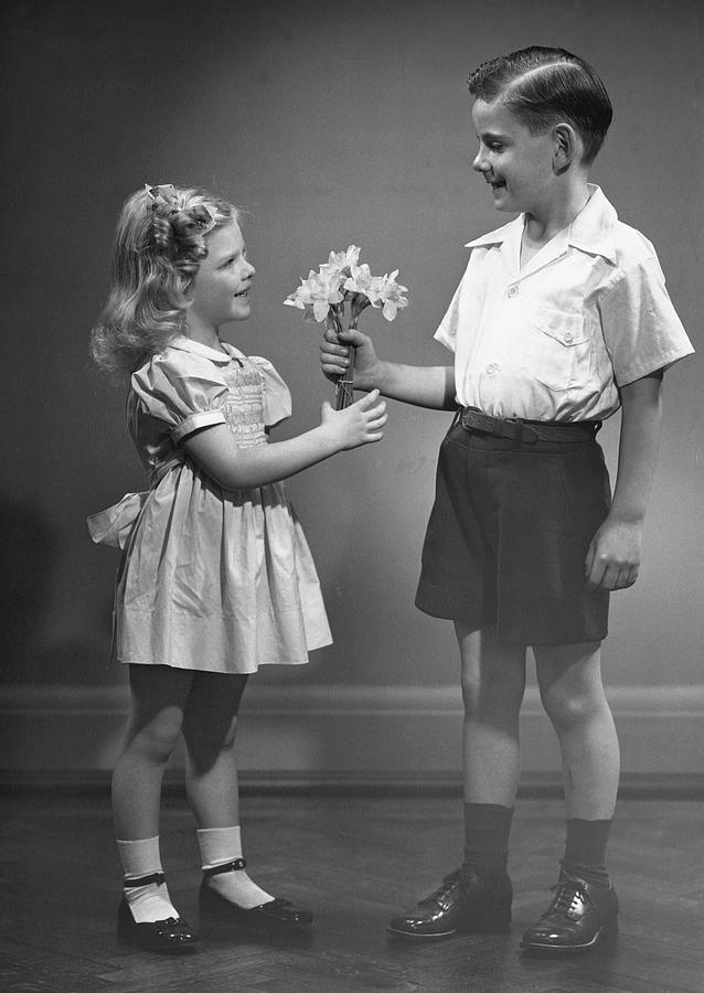 Boy Giving Flowers To Girl Photograph by George Marks