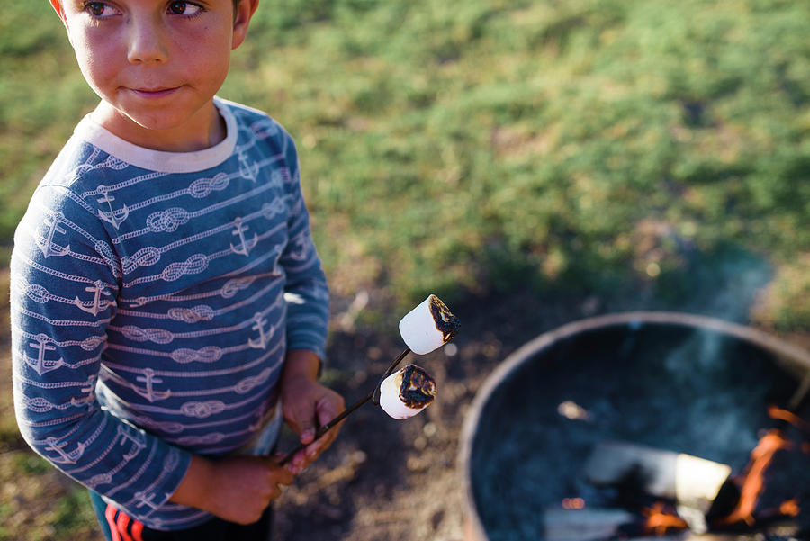 Nature Photograph - Boy Looking Away While Roasting Marshmallows In Campfire On Field by Cavan Images