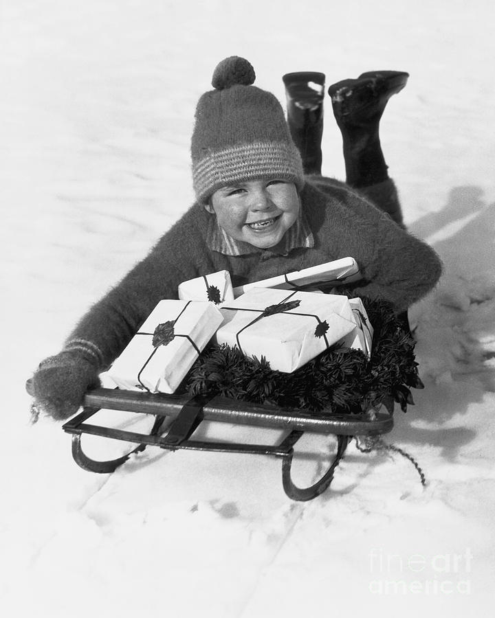Boy On Sled With Christmas Gifts Photograph by Bettmann