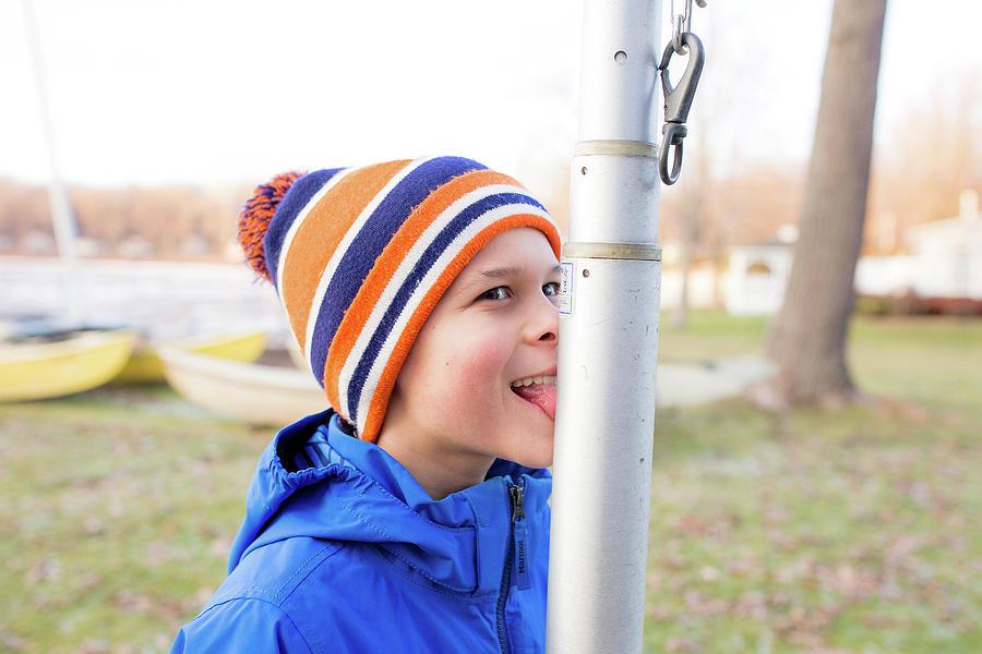 Boy Outside Sticking Tongue Out Onto Flagpole Photograph by Cavan
