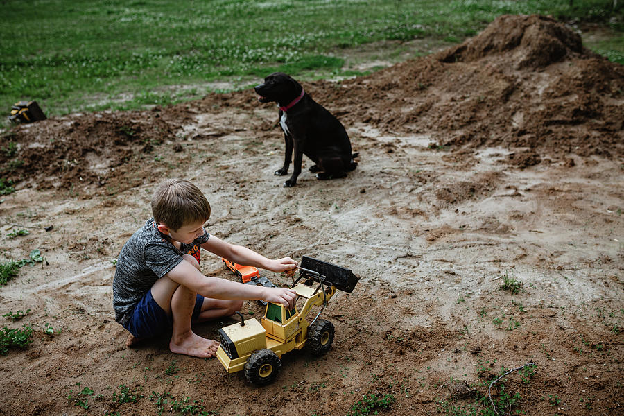 Summer Photograph - Boy Playing Tractors In Dirt In Yard At Home by Cavan Images / Krista Taylor