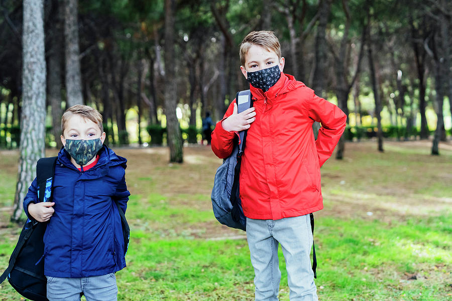 Boy Putting On His School Backpack Photograph by Cavan Images