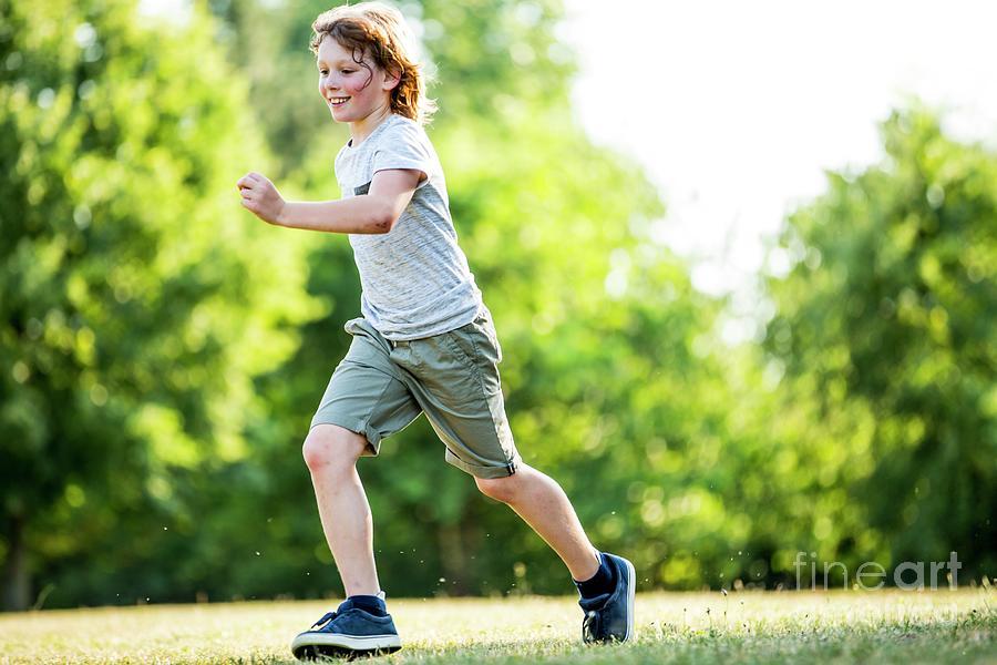 Boy Running In Park by Science Photo Library