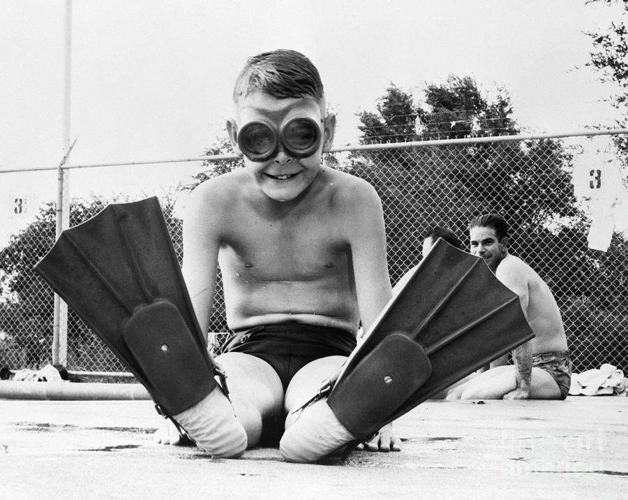 Boy Seated In Swimming Goggles & Fins Photograph by Bettmann