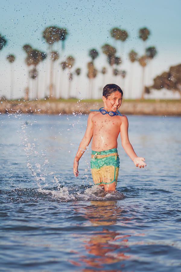 Boy Splashing Water At The Bay In The Summer Time. Photograph by Cavan ...