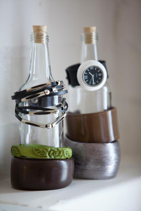 Bracelets And Watch On Bottles Used As Jewellery Stands Photograph by Great Stock!