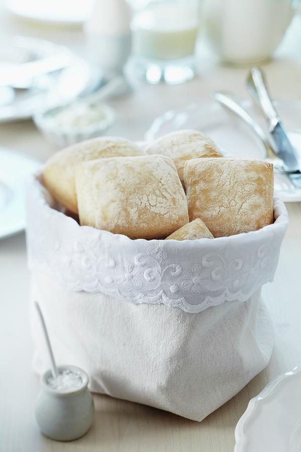 Bread Bag Decorated With Lace Trim On Breakfast Table Set In White Photograph by Franziska Taube