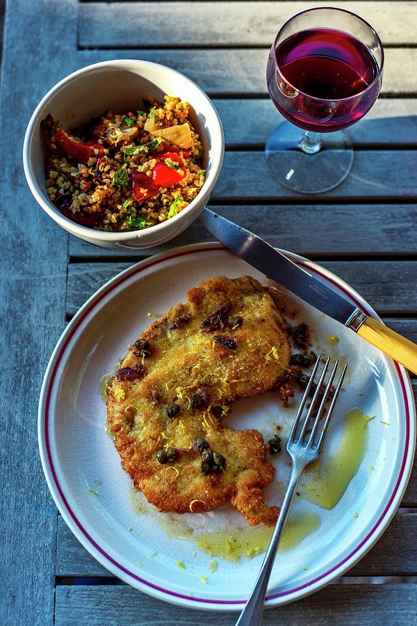 Breaded Turkey Schnitzel With Lemon And Caper Sauce Photograph by Roger Stowell