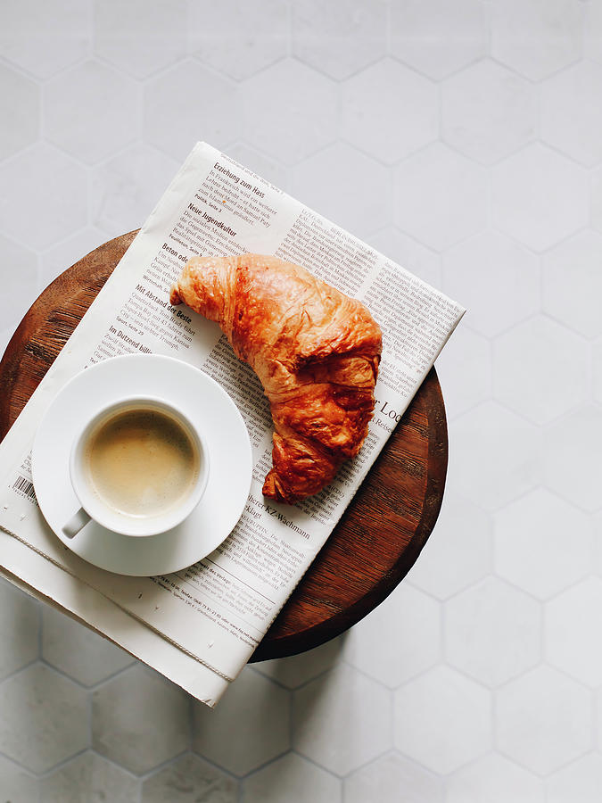 Breakfast Croissant, Cup Of Coffee And Newspaper On A Wooden Stool Photograph by Paulina Sauer